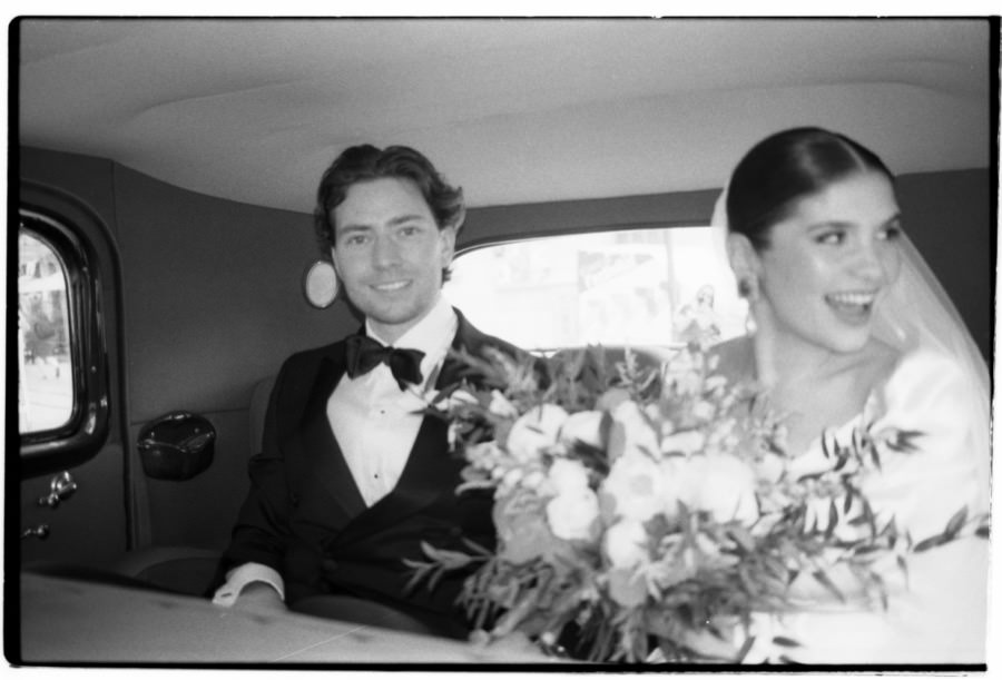 Couple in a vintage car after their wedding ceremony