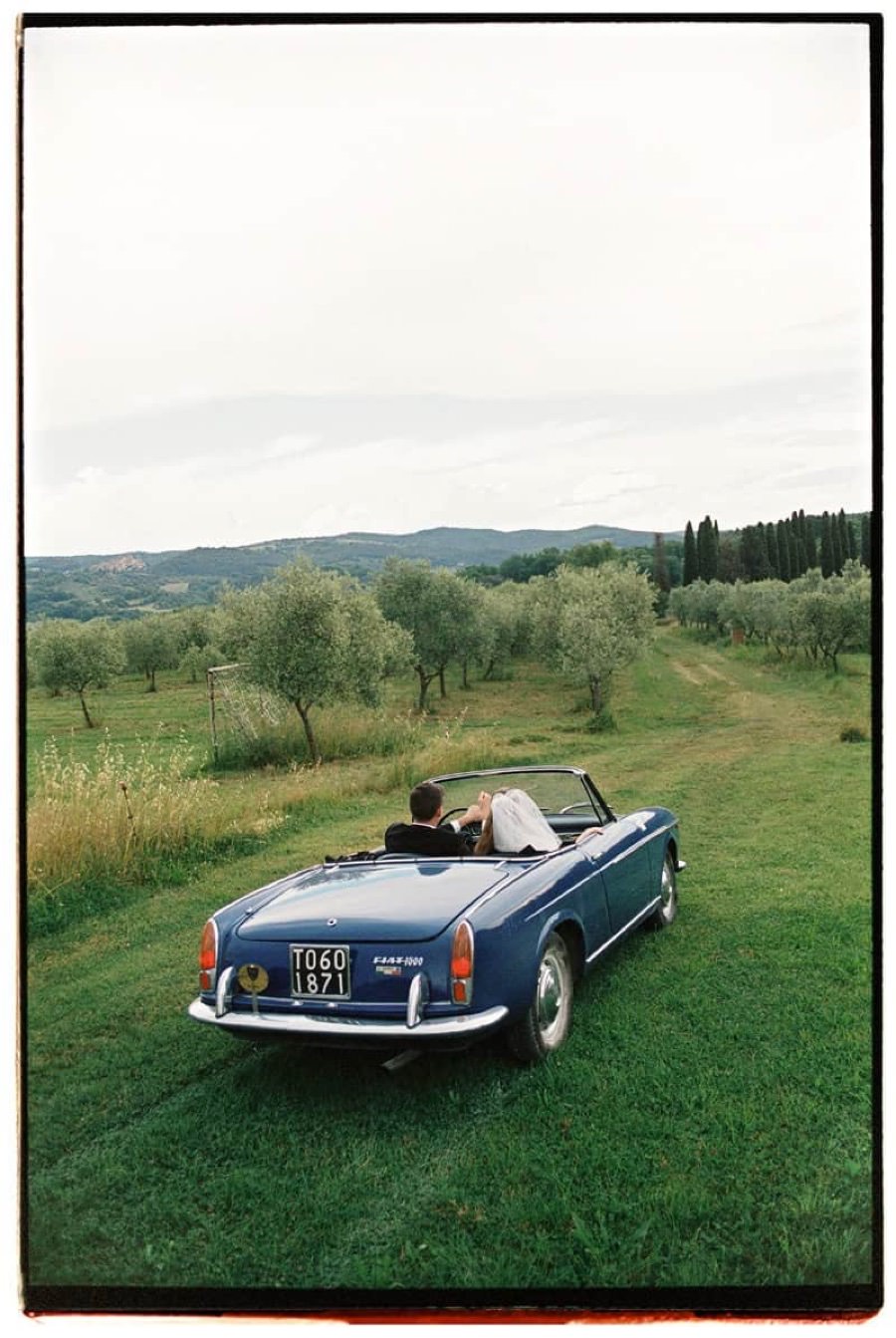 Wedding couple in a vintage car in Tuscany